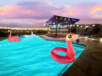 a pool with two inflatable flamingos in the water at Half ACRE Lux Pool SPA with FIREPIT ARCADE Grill Sleeps 40 in El Cajon