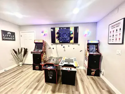 a room with three video game machines in it at Half ACRE Lux Pool SPA with FIREPIT ARCADE Grill Sleeps 40 in El Cajon