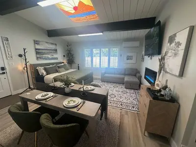 a living room with a bed and a table and chairs at Half ACRE Lux Pool SPA with FIREPIT ARCADE Grill Sleeps 40 in El Cajon