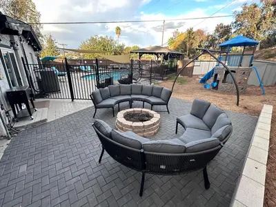 a patio with couches and a fire pit and a playground at Half ACRE Lux Pool SPA with FIREPIT ARCADE Grill Sleeps 40 in El Cajon