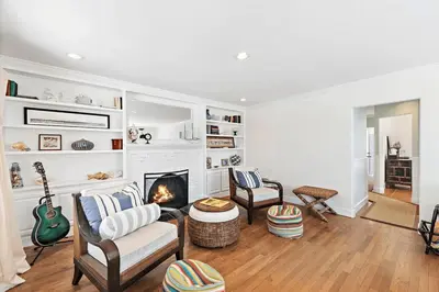 a living room with a fireplace and two chairs at Luxurious Seaside Escape-85 Steps to the Beach-Panoramic Ocean Views in Laguna Beach