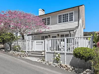 a white fence in front of a house at Luxurious Seaside Escape-85 Steps to the Beach-Panoramic Ocean Views in Laguna Beach