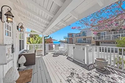 an outdoor deck with a white fence and a view of the ocean at Luxurious Seaside Escape-85 Steps to the Beach-Panoramic Ocean Views in Laguna Beach