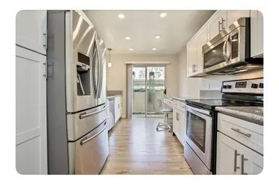 a kitchen with stainless steel appliances and white cabinets at Ritz Pointe dr in Dana Point