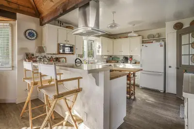 a kitchen with white cabinets and a white refrigerator at Gated Lakefront Estate - Seaside with Private Beach in Oceanside