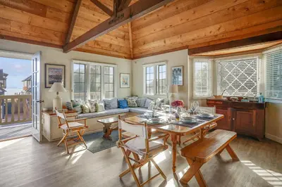 a dining room with a table and chairs and a couch at Gated Lakefront Estate - Seaside with Private Beach in Oceanside