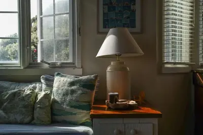 a lamp sitting on a table next to a couch at Gated Lakefront Estate - Seaside with Private Beach in Oceanside