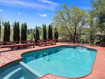 a swimming pool on a patio with benches around it at Autumn Room at Eaglenest Inn with Pool and SPA in Julian