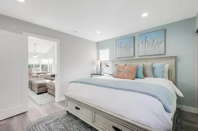a bedroom with a large bed and a living room at Luxury Meets Coastal Charm in North Mission Beach in San Diego
