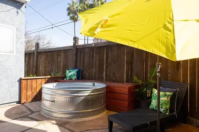 a yellow umbrella and a barrel on a patio at Modern Retro Close to DT, Zoo, Parking, Hot Tub in San Diego