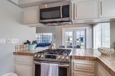 a kitchen with a stove and a microwave at Half block to bay steps to ocean AC large patio in San Diego