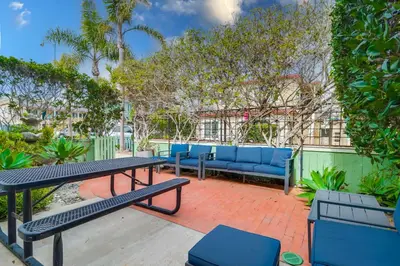 a patio with a picnic table and blue benches at Half block to bay steps to ocean AC large patio in San Diego