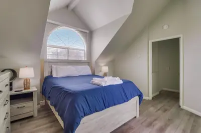 a bedroom with a blue bed and a window at Steps to bay & ocean Belmont Park dining in San Diego