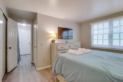 a bedroom with a bed and a dresser and a window at Steps to bay & ocean Belmont Park dining in San Diego