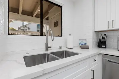 a white kitchen with a sink and a window at Trackside Tranquility - TC522B in Solana Beach