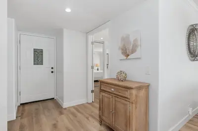 a white room with a wooden cabinet and a door at Trackside Tranquility - TC522B in Solana Beach