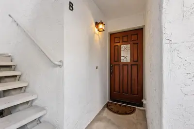 a hallway with a wooden door and stairs at Trackside Tranquility - TC522B in Solana Beach
