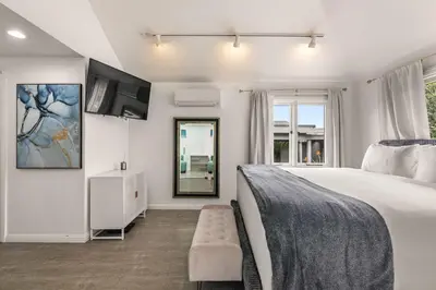 a bedroom with a large bed and a mirror at Chic La Jolla Studio Steps to Ocean & Dining in San Diego