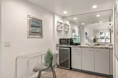 a white kitchen with a sink and a microwave at Chic La Jolla Studio Steps to Ocean & Dining in San Diego