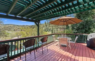 a deck with a table and chairs and an umbrella at Eaglenest Inn with Pool & Seasonal SPA in Julian
