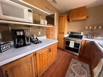a kitchen with wooden cabinets and a microwave at Whole House at Eaglenest Inn with Pool & Seasonal SPA in Julian