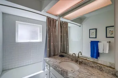 a bathroom with a sink and a mirror at Luxury summer house feet from bay & ocean patios in San Diego