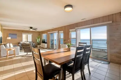 a dining room and living room with a table and chairs at Oceanfront Getaway Ocean Views Fire Pit BBQ Beach Access in Carlsbad