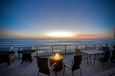 a patio with a table and chairs and the ocean at Oceanfront Getaway Ocean Views Fire Pit BBQ Beach Access in Carlsbad