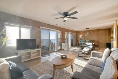 a living room with a couch and a flat screen tv at Oceanfront Getaway Ocean Views Fire Pit BBQ Beach Access in Carlsbad