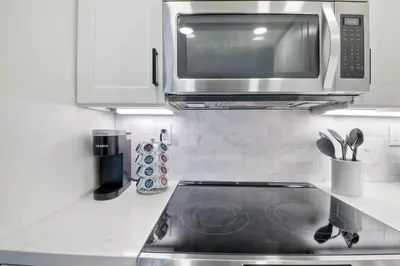 a kitchen with a microwave and a stove top oven at 2003 Costa Del Mar Road - Unit 676 in Carlsbad