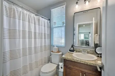 a bathroom with a toilet and a sink and a mirror at 301 Cassidy Street Unit 10 in Oceanside
