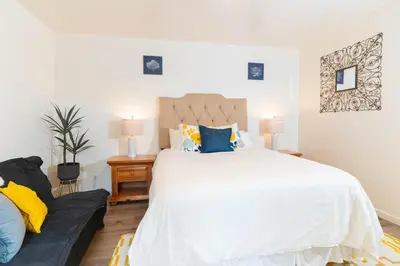 a bedroom with a large white bed and a couch at Beachwalk Villas in Carlsbad