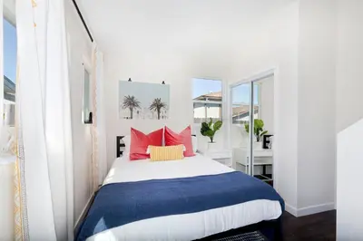 a bedroom with a large bed with red pillows at Comstock in San Diego
