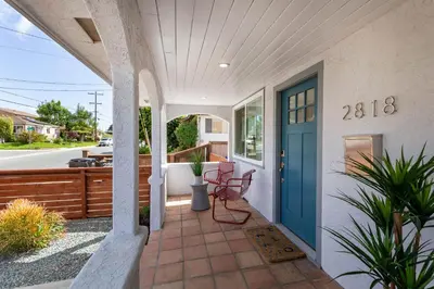 a porch of a house with a blue door at Comstock in San Diego