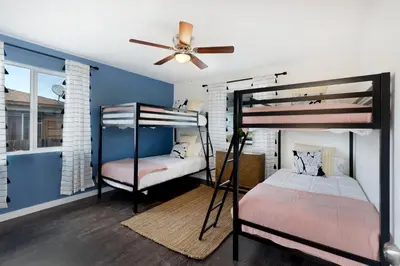 two bunk beds in a room with a ceiling fan at Comstock in San Diego