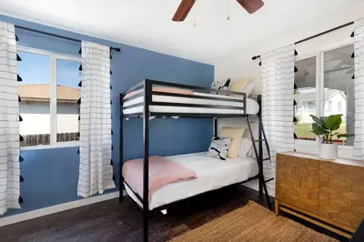 a bedroom with a bunk bed and a blue wall at Comstock in San Diego