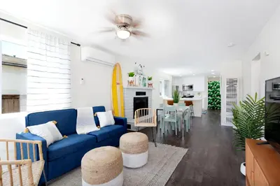 a living room with a blue couch and a surfboard at Comstock in San Diego