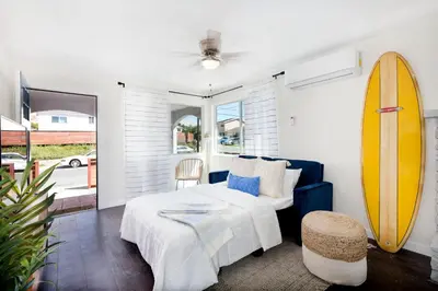 a bedroom with a bed and a surfboard on the wall at Comstock in San Diego