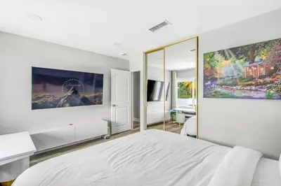 a bedroom with a white bed and a large painting on the wall at MV Retreat Pool Spa Fire Pit Family Friendly in Mission Viejo