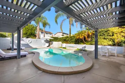 a patio with a swimming pool under a pergola at MV Retreat Pool Spa Fire Pit Family Friendly in Mission Viejo