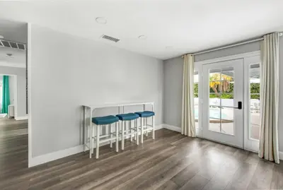 a living room with white walls and blue stools at MV Retreat Pool Spa Fire Pit Family Friendly in Mission Viejo