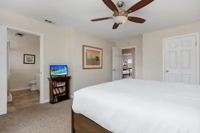 a bedroom with a white bed and a ceiling fan at Bask in the Breeze - DMBC146N in Solana Beach