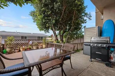 a patio with a grill and a table and chairs at Bask in the Breeze - DMBC146N in Solana Beach