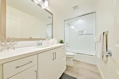 a white bathroom with a toilet and a large mirror at 343 Oak Avenue in Carlsbad