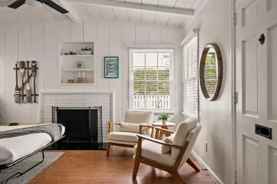a bedroom with a bed and a chair and a fireplace at Coastal Retreat 1BR Steps to Ocean & Peek Views in San Diego