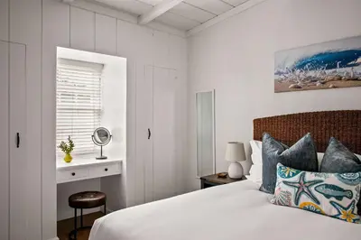 a white bedroom with a bed and a window at Ocean Escape 1BR Walk to Windansea Beach in San Diego