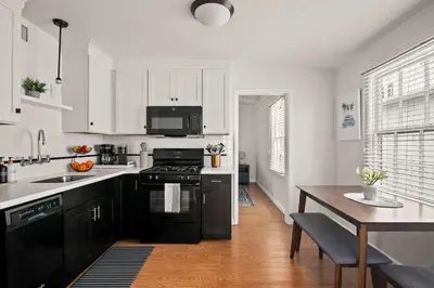 a kitchen with black and white appliances and a table at Ocean Escape 1BR Walk to Windansea Beach in San Diego