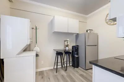 a kitchen with white cabinets and a refrigerator at Outdoor Oasis with Pool and Hot Tub Perris Getaway in Perris