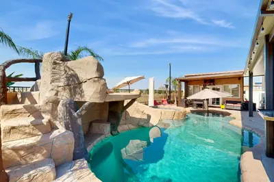 a water slide at a resort with a swimming pool at Outdoor Oasis with Pool and Hot Tub Perris Getaway in Perris