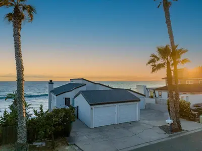 a house on the beach with palm trees and the ocean at 1317 S Pacific - Unit A in Oceanside